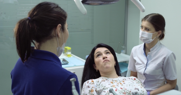 dentist check the teeth of a young woman with the mirror dental dentel nurse