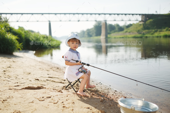 happy girl with rod on coast of river Stock Photo by ababaka