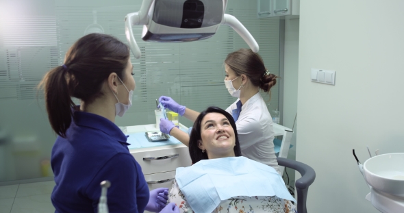 dentist make a checkup and dental cleaning for a young woman dentel nurse