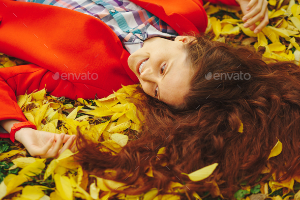Young beautiful lady surrounded autumn leaves - Stock Photo - Images