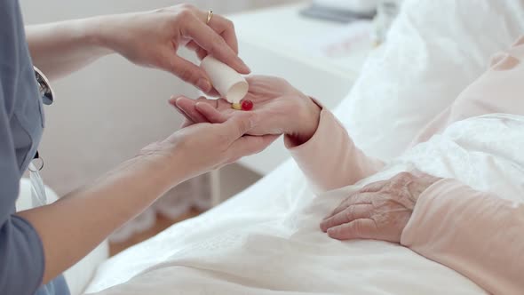 Close up of Nurse Administering Medications to Female Senior Patient
