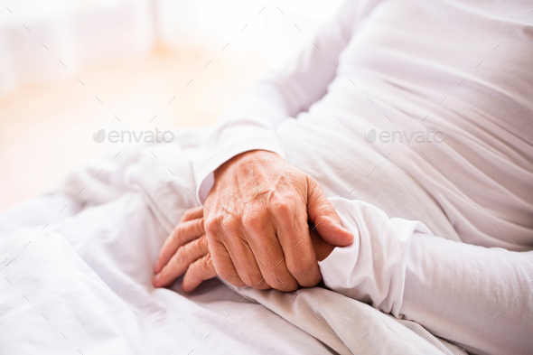 Senior man lying in bed at home.