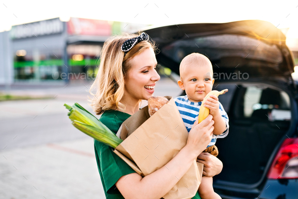 Young mother with baby boy in front of a supermarket. - Stock Photo - Images