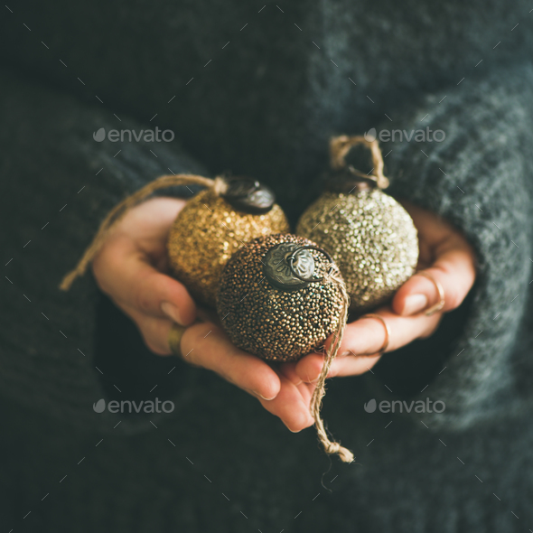 Woman holding golden and silver toy balls in hands - Stock Photo - Images