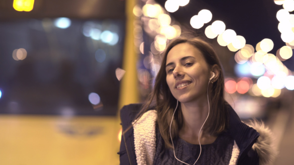 Young Happy Woman Listening to Music and Dancing