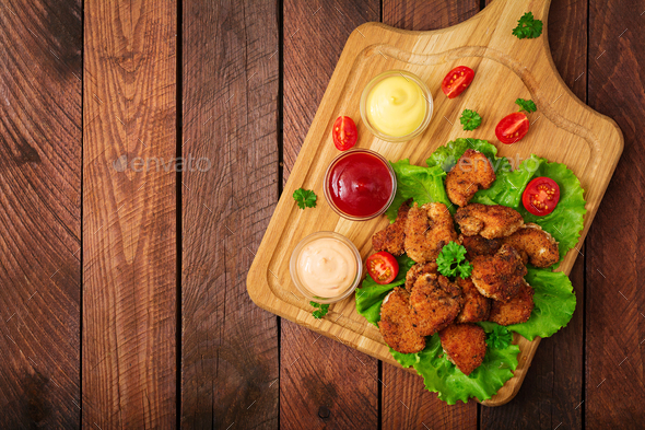 Chicken nuggets and sauce on a wooden background. Flay lay. Top view
