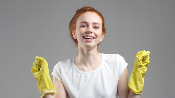 Portrait of Young Woman in Rubber Gloves Looks at Camera Smiling. Concept of Cleaning, Cleanliness. alt