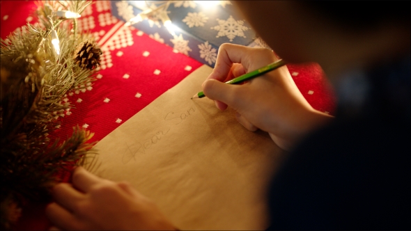 of Female Hands Writing Christmas Letter with Her Wishlist on New Years Night alt