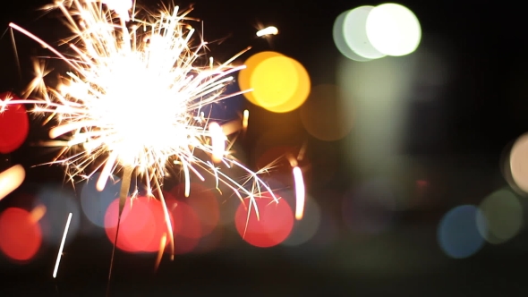 Burning Sparkler On Bokeh Light Background