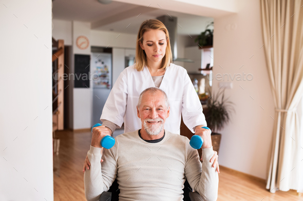 Nurse and senior man in wheelchair during home visit. - Stock Photo - Images