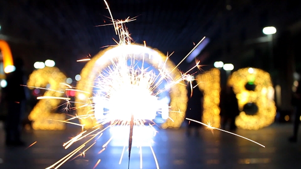 Burning Sparkler on the Cityscape Background of the Scenery with Lamps Sign 2018