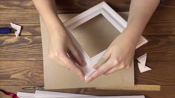 Women's Hands Gluing Frames Made of Styrofoam