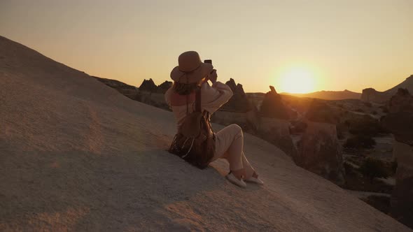 Woman Photographing the Valley of the Monks at Sunset alt