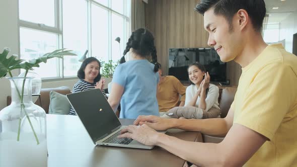 Asian father use laptop work at home with big family mom ,daughter ,grandfather grandmother alt