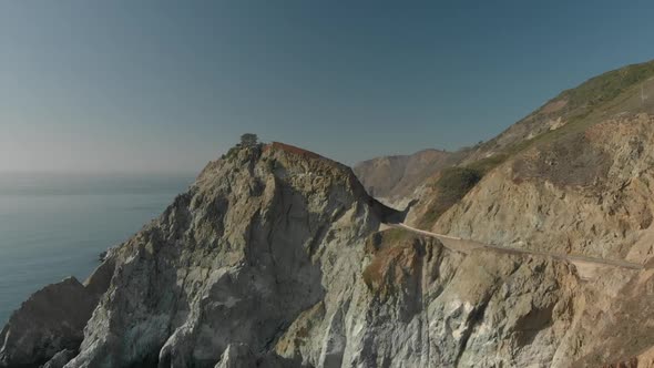 Aerial Push In of Tree on Rock on California Coast Highway One alt