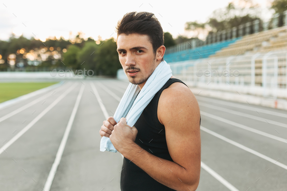 Portrait of a fitness man with towel on shoulders resting after - Stock Photo - Images
