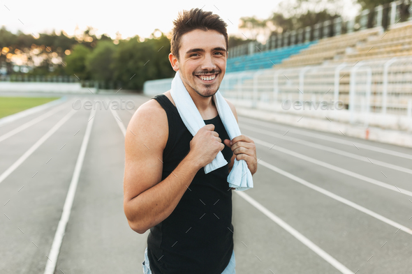 Portrait of a smiling fitness man with towel on shoulders - Stock Photo - Images
