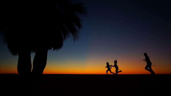 A Man Runs After the Boy and Girl on the Beach