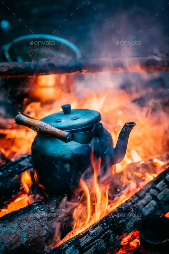 Old Retro Iron Camp Kettle Boiling Water On A Fire In Forest. Br