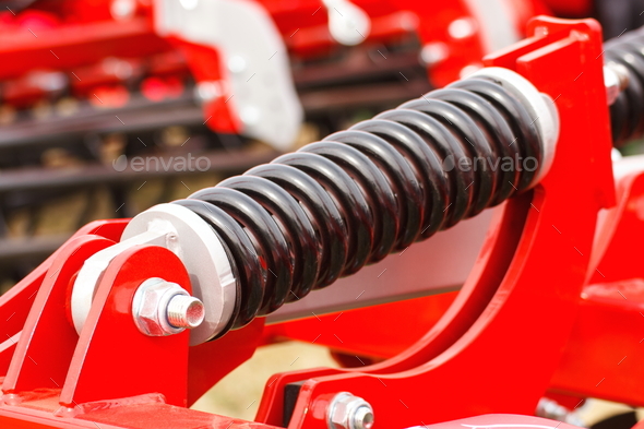 Steel spring on industrial or agricultural machinery, technology and engineering - Stock Photo - Images