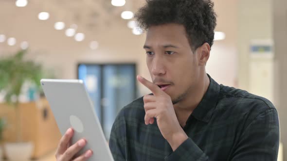 African American Man Reacting to Loss on Digital Tablet alt