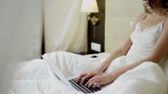 Joyful Woman Working on Her Laptop in the Morning on Bed