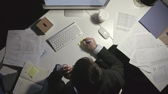 Man Taking Notes While Talking on Phone alt
