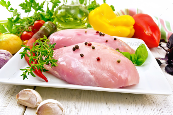 Chicken breast raw in plate with vegetables on board - Stock Photo - Images