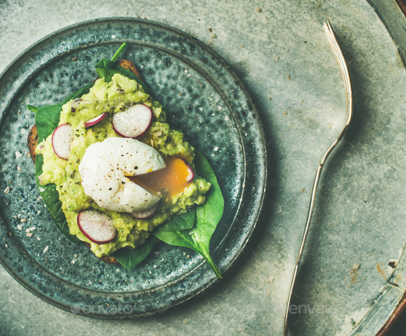 Healthy vegetarian wholegrain avocado toasts with poached egg, top view - Stock Photo - Images