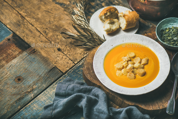 Warming pumpkin cream soup with croutons and seeds, selective focus - Stock Photo - Images