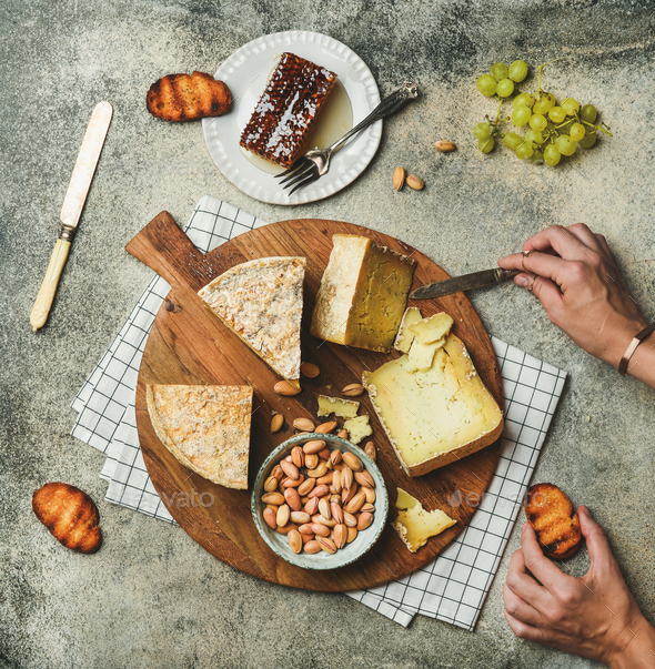 Cheese platter with female hands reaching to food, flat-lay - Stock Photo - Images