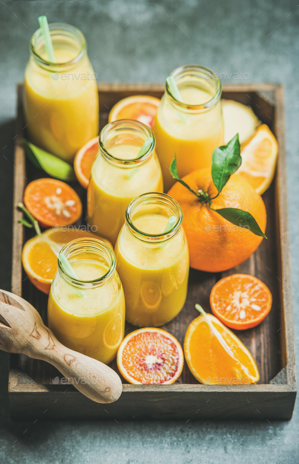Healthy yellow smoothie in bottles in wooden tray - Stock Photo - Images
