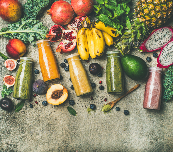 Colorful smoothies in bottles with fresh tropical fruit, copy space - Stock Photo - Images