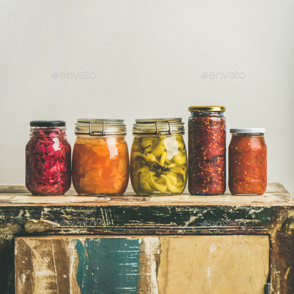 Autumn pickled vegetables in jars placed in line, square crop - Stock Photo - Images