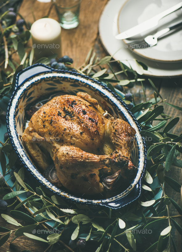 Whole roasted chicken decorated with olive tree branch on table - Stock Photo - Images