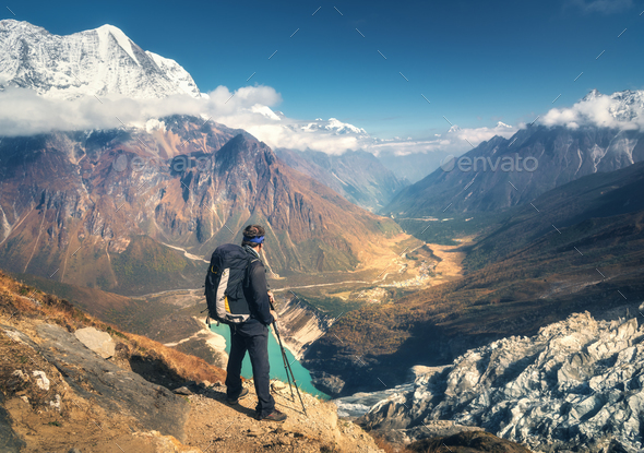 Standing sporty man with backpack on the mountain peak - Stock Photo - Images