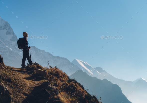 Standing young woman on the hill and looking on mountains - Stock Photo - Images
