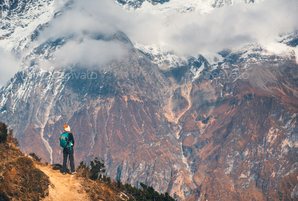 Young woman with backpack on the mountain peak
