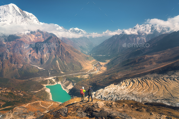 Standing men with backpacks on the mountain peak - Stock Photo - Images