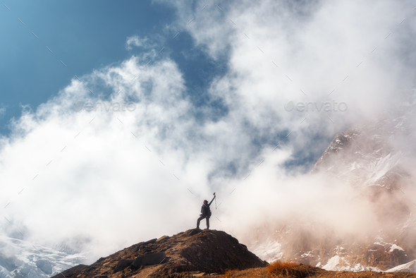 Young woman with raised up arms on the mountain peak - Stock Photo - Images