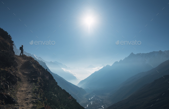 Standing young woman on the hill and looking on mountains - Stock Photo - Images