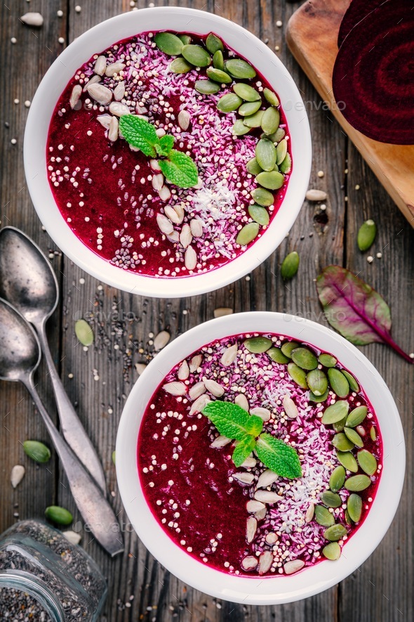 Beet smoothie bowl with chia seeds, coconut, pumpkin seeds, quinoa, sunflower seeds and mint - Stock Photo - Images
