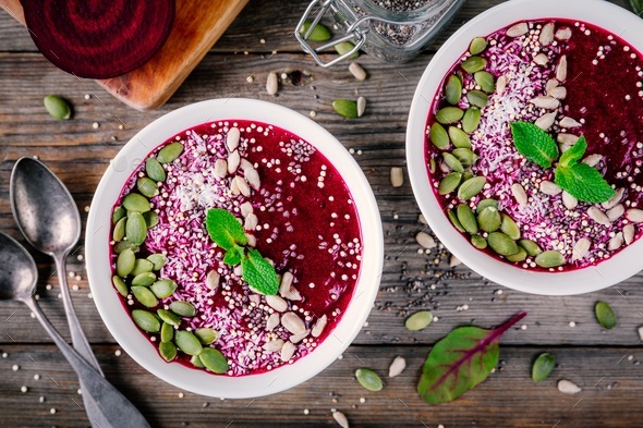 Beet smoothie bowl with chia seeds, coconut, pumpkin seeds, quinoa, sunflower seeds and mint - Stock Photo - Images