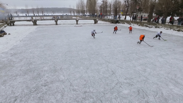Aerial View of Men Playing Hockey on a Frozen Lake in a City Park in Winter