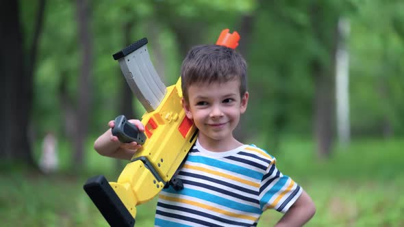 Portrait Boy with Large Toy Weapons Outdoors
