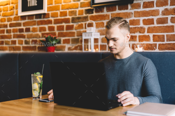 Young man working in a restaurant. Freelance job.