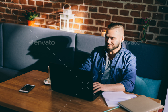 Handsome man doing paperwork in a restaurant - Stock Photo - Images