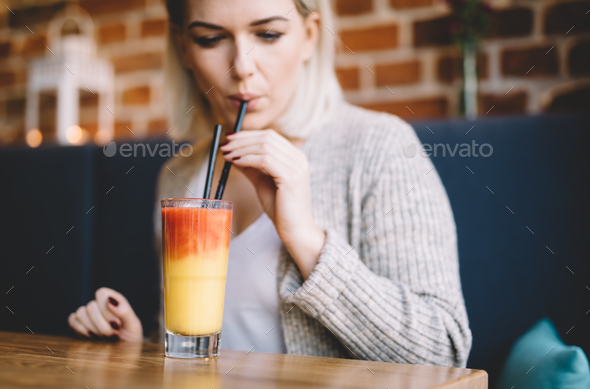 Young woman sipping a healthy smoothie in a restaurant.