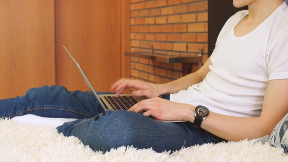 Young Businessman Works Using Laptop at Home. alt