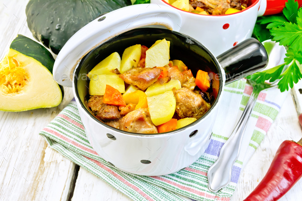 Roast meat and vegetables in white pots on towel - Stock Photo - Images